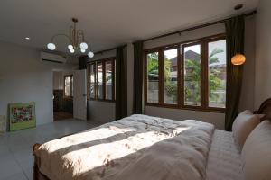 a bedroom with a large bed and a large window at 清迈古城柚子别墅塔佩门里 in Chiang Mai