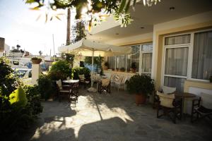 a patio with tables and chairs and an umbrella at Kalliopi Hotel in Kastéllion
