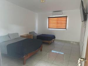- une chambre avec 2 lits et une fenêtre dans l'établissement Habitaciones ENMA, à Ciudad Juárez