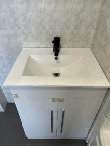 a white bathroom sink with a black faucet at APD HOTEL in Montreal