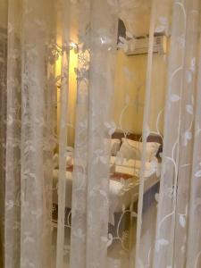 um quarto com cortinas brancas e camas num quarto em Meet sunset hostel Luangprabang em Luang Prabang
