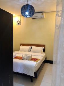 a bedroom with a bed with white sheets and a blue light at Meet sunset hostel Luangprabang in Luang Prabang