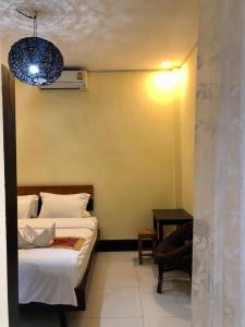 a bedroom with a bed and a chair and a lamp at Meet sunset hostel Luangprabang in Luang Prabang