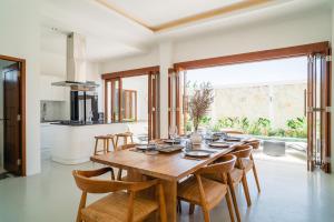 a kitchen and dining room with a wooden table and chairs at Cosy and Luxurious Villa Sentosa Seminyak in Seminyak