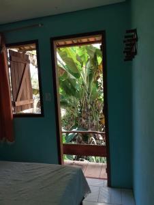 een kamer met een slaapkamer met een bed en een raam bij Kalena Suítes in Lençóis