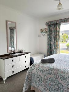 a bedroom with a bed and a dresser and a mirror at Home away from home in Christchurch