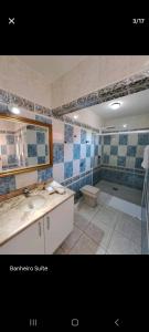 uma casa de banho com um lavatório, um espelho e uma banheira em Conforto em local privilegiado em Itajaí