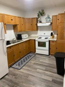 a kitchen with wooden cabinets and a white stove top oven at Almost Bearadise in Pikeville