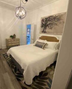 Un dormitorio con una gran cama blanca y una lámpara de araña. en Almost Bearadise, en Pikeville