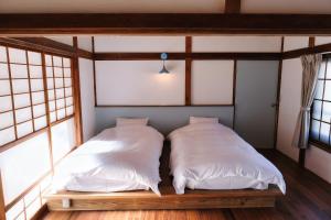 two beds in a room with windows at palette in Numazu