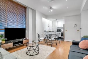 un soggiorno con divano e tavolo con sedie di Cliveden - A Heritage Hideaway with Rooftop Pool a Sydney