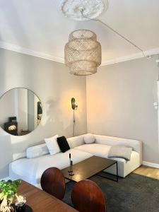 a living room with a white couch and a mirror at Alexander Kiellands plass - City Center Oslo in Oslo