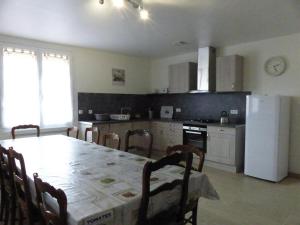a kitchen with a table and a white refrigerator at Spacieuse maison rénovée, nature verdoyante - FR-1-489-176 in Valigny