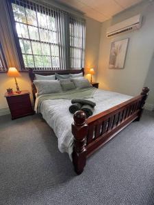 a bedroom with a large bed with two windows at Post Office Boutique Accommodation in Hat Head