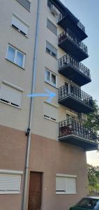 un edificio con balconi e freccia blu di Dunja ambient a Kraljevo
