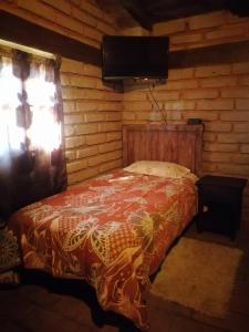 a bedroom with a bed in a log cabin at Cabaña El Fresno 
