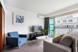 uma sala de estar com um sofá e uma televisão em Luxury Hideaway On Princes Wharf em Auckland