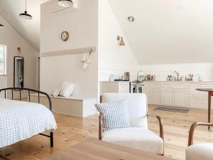 uma cozinha com armários brancos e uma mesa e cadeiras em Homestead Barn Loft em Sonora