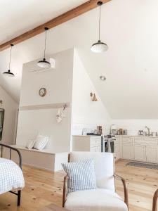 a white living room with a couch and a chair at Homestead Barn Loft in Sonora