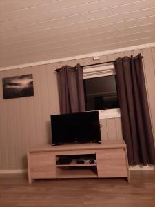 une télévision à écran plat installée au-dessus d'une table. dans l'établissement Kleines Haus am Fjord, 