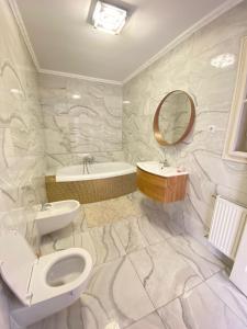 a white bathroom with a toilet and a sink at Penthouse in the castle in Budapest