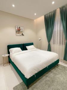 a bedroom with a large bed with a green frame at نزل الراشد الفاخرة luxury in Abha