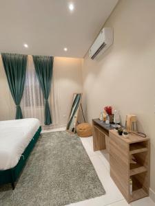 Schlafzimmer mit einem Bett, einem Schreibtisch und einem Fenster in der Unterkunft نزل الراشد الفاخرة luxury in Abha
