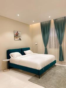 a bedroom with a blue bed and a window at نزل الراشد الفاخرة luxury in Abha