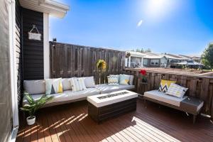 a patio with a couch and benches on a deck at Le Cozy Clover in Moncton