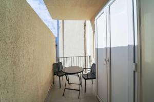 einen Balkon mit einem Tisch und Stühlen in einem Gebäude in der Unterkunft Studio with balcony on Melikishvili, city center in Tbilisi City