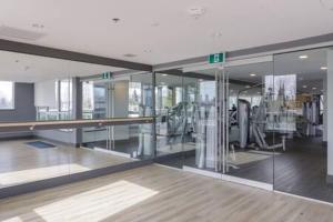 an empty room with glass walls and a gym at Luxury Oceanfront 1BR condo at Lions Gate in North Vancouver