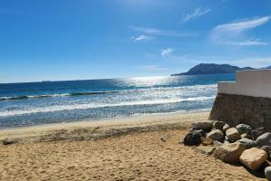 einen Strand mit Felsen auf dem Sand und dem Meer in der Unterkunft Casa Ola Blanca in Manzanillo