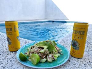 ein Teller mit Essen auf einem Tisch neben einem Pool in der Unterkunft Casa Ola Blanca in Manzanillo