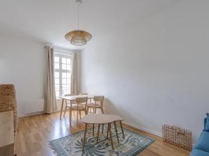 una sala de estar con mesas, sillas y una ventana en Studio La Rochelle, 1 pièce, 2 personnes - FR-1-535-53, en La Rochelle