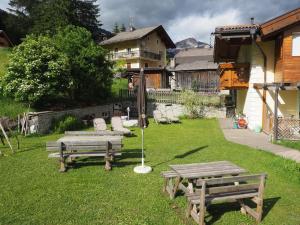 a yard with two picnic tables and chairs on the grass at Residence Rodolon Appartamenti in Campestrin