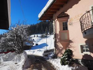 a house with snow on the ground next to a building at Residence Rodolon Appartamenti in Campestrin