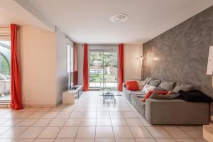 uma sala de estar com um sofá e cortinas vermelhas em ALPILOC - Town house with garden and winter lounge em Annecy