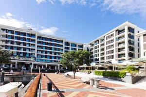 a large white building with a plaza in front of it at The Sunset Suite in Auckland