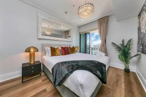 Un dormitorio con una cama grande y una lámpara de araña. en The Sunset Suite, en Auckland