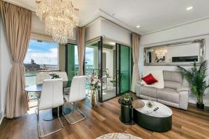 a living room with a table and a chandelier at The Sunset Suite in Auckland