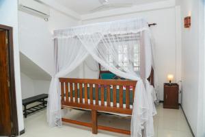 a wooden bench in a room with a curtain at The Heavens Ocean Villa Talpe in Talpe