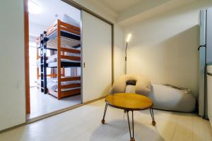 ein Schlafzimmer mit einem Tisch, einem Bett und einem Spiegel in der Unterkunft Aoi home Nipponbashi in Osaka