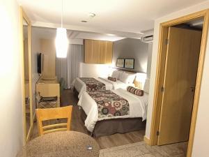 a hotel room with two beds and a table at RARIDADE!!! - Flat Particular de Alto Padrão - Limpeza Diária Gratuita - Excelente Atendimento - Ótimo Preço - Cama King ou Queen Size - Condomínio do Hotel Lets Idea in Brasília