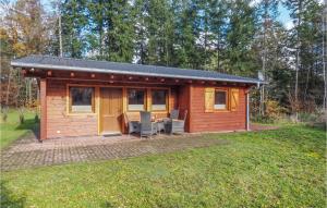 a log cabin with a patio in a yard at Awesome Home In Merzalben With Wi-fi in Merzalben