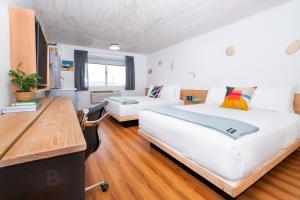 a hotel room with two beds and a desk at Anacortes Inn in Anacortes