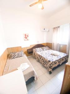 1 dormitorio con 2 camas, mesa y ventana en Hotel Atlantico, en Piriápolis