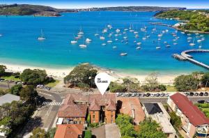 an aerial view of a harbor with boats in the water at Luxe-Coastal Balmoral Beachfront Apartment in Sydney
