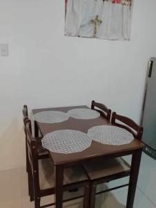 a wooden table with two chairs and a cross on top at Uptown Condominium Primavera Residences in Cagayan de Oro
