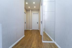 an empty hallway with white walls and wood floors at Hotel type rooms on avenue Melikishvili, city center in Tbilisi City