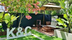 a garden with a bench and an umbrella at Moulmein Studios by K&C Serviced Apartment in Singapore